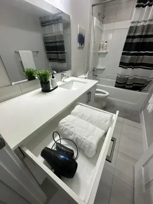 a white bathroom with a sink and a toilet at A Luxurious Cozy Place in Calgary