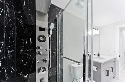 a bathroom with a shower with a toilet and a sink at Executive Bliss Suites in Calgary