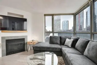 a living room with a couch and a fireplace at Luxury Condo in Downtown Vancouver with city view in Vancouver