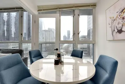 a dining room with a white table and blue chairs at Luxury Condo in Downtown Vancouver with city view in Vancouver
