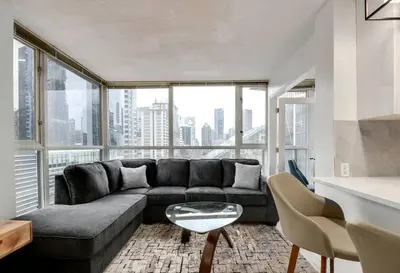 a living room with a couch and a large window at Luxury Condo in Downtown Vancouver with city view in Vancouver