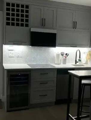 a kitchen with white cabinets and a sink and a stove at Modern West Coast Contemporary Suite in Vancouver