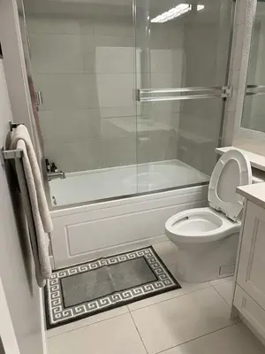 a bathroom with a toilet and a glass shower at Modern West Coast Contemporary Suite in Vancouver
