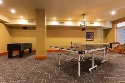 a room with two ping pong tables and a ping pong table at Slalom Creek 2 Bedroom & Den in Rossland