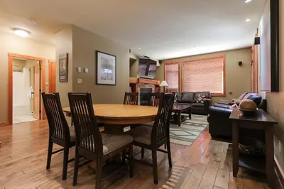 a dining room and living room with a table and chairs at Slalom Creek 2 Bedroom & Den in Rossland
