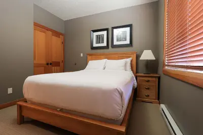 a bedroom with a large bed and a window at Slalom Creek 2 Bedroom & Den in Rossland