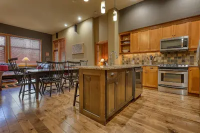 a large kitchen with a table and a dining room at Slalom Creek 3 Bedrooms in Rossland