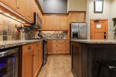 a kitchen with wooden cabinets and stainless steel appliances at Slalom Creek 3 Bedrooms in Rossland
