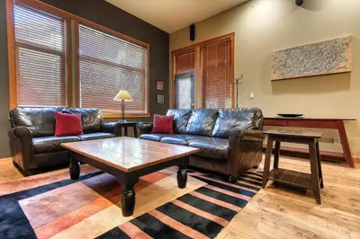 a living room with leather couches and a coffee table at Slalom Creek 3 Bedrooms in Rossland