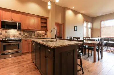 a kitchen with a kitchen island and a dining room at Slalom Creek 2 Bedrooms in Rossland