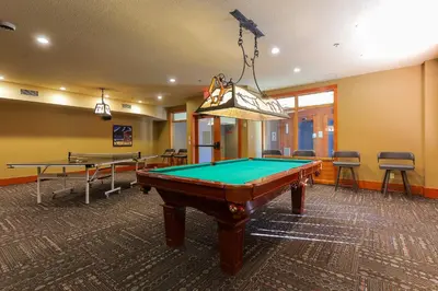 a pool table in a room with two tables at Slalom Creek 3 Bedroom in Rossland