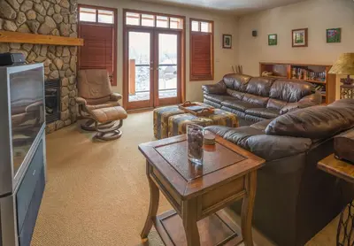 a living room with leather couches and a fireplace at Silver Tip 2 Bedroom Condo in Rossland