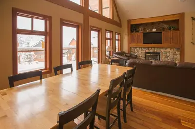 a dining room with a table and chairs and a fireplace at White Wolf in Rossland