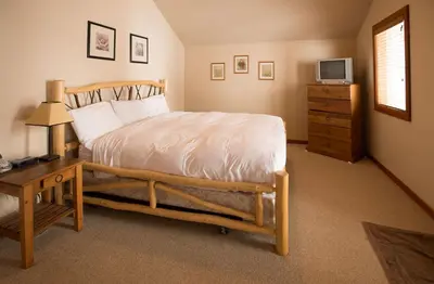 a bedroom with a bed and a desk and a television at White Wolf in Rossland