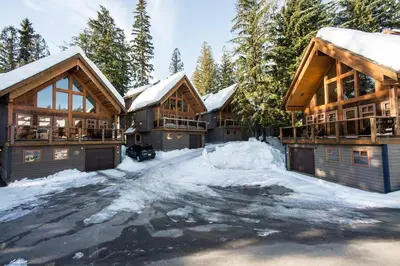 a log home in the snow with a driveway at White Wolf in Rossland