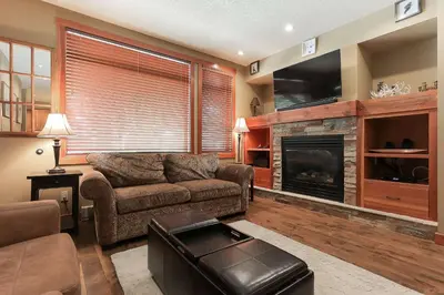 a living room with a couch and a fireplace at Slalom Creek 2 Bedroom & Den in Rossland