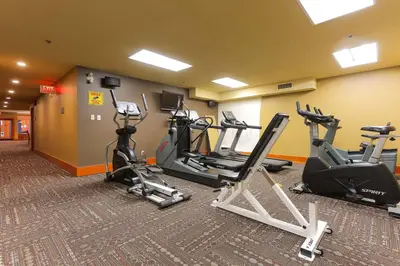 a gym with several treadmills and elliptical machines at Slalom Creek 2 Bedroom & Den in Rossland