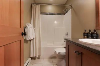 a bathroom with a shower and a toilet and a sink at Slalom Creek 2 Bedroom & Den in Rossland