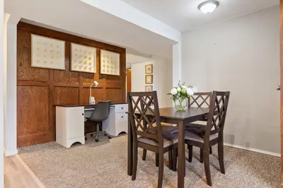 a dining room with a desk and a table with chairs at 2BR Cozy Suite w Fireplace! FREE Banff Pass, Parking, Netflix! Near Golf Course! in Calgary