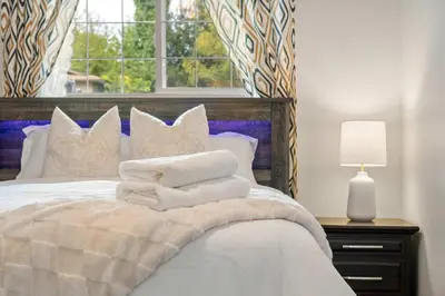 a bedroom with a bed with white pillows and a window at 2BR Cozy Suite w Fireplace! FREE Banff Pass, Parking, Netflix! Near Golf Course! in Calgary