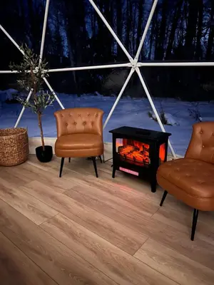 two chairs and a fireplace in a tent at Experience Luxury Glamping at Ravines Edge Geo Glamping in Devon