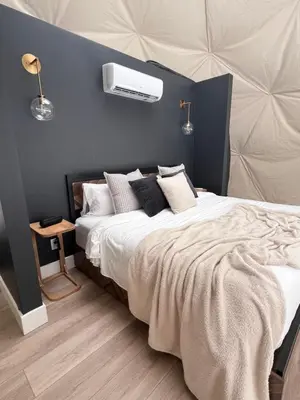 a bedroom with a large bed with a blue wall at Experience Luxury Glamping at Ravines Edge Geo Glamping in Devon