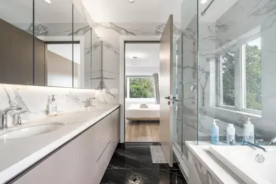 a white bathroom with two sinks and a shower at Charming and Modern Retreat in Vancouver Trendy 42nd Avenue Neighbourhood in Vancouver