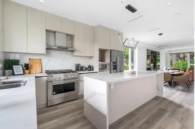 a kitchen with white cabinets and a kitchen island at Charming and Modern Retreat in Vancouver Trendy 42nd Avenue Neighbourhood in Vancouver