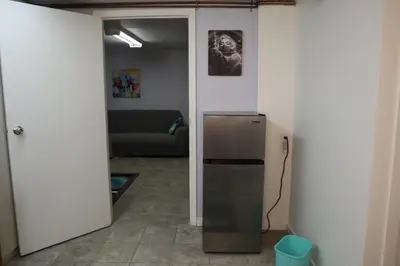 a living room with a refrigerator and a couch at Calgary's Home Cinema Retreat in Calgary