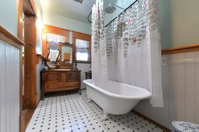 a bathroom with a white tub and a shower at Hummingbird Gardens B&B in Ladysmith