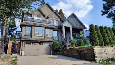 a large house with a garage in front of it at Angela's Private Suites in Surrey