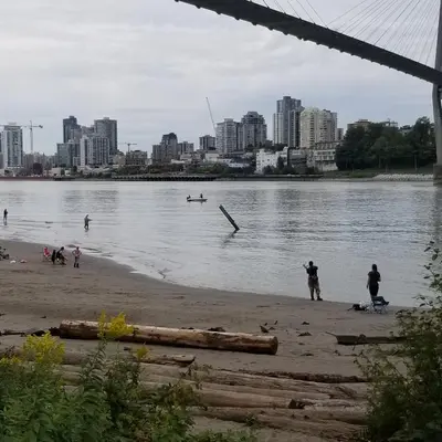a group of people standing on a beach near the water at Angela's Private Suites in Surrey