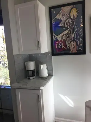a kitchen with a coffee maker and a painting at Trader Vics Tiki Bar n Grill in Nanaimo