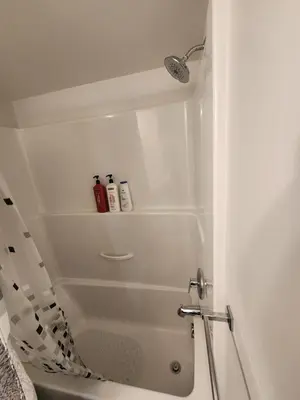 a bathroom with a shower with a shower curtain at Cozy Royal Bay Suite in Victoria