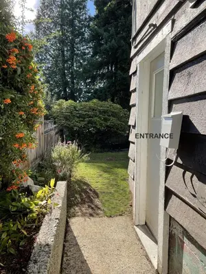 a window on the side of a house with a garden at Almost Home in West Vancouver