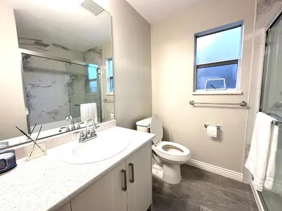 a bathroom with a sink and a toilet and a window at Newly renovated 2 bed 1 bath in Ladner BC in Delta
