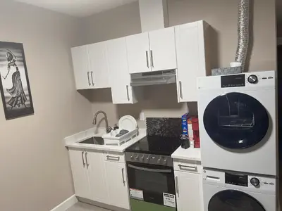 a kitchen with a washing machine and a sink at Home away from home in Prince George