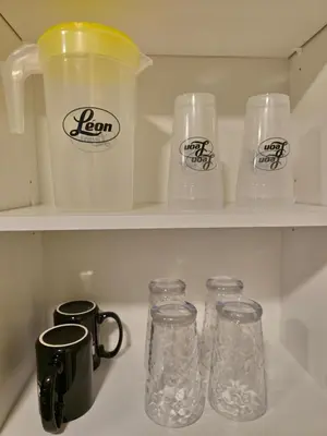 a kitchen shelf with glass jars and a coffee mug at A stylish 2 BDR with a blend of cozy and peace! in Calgary