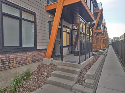 a home with a porch and stairs on it at A stylish 2 BDR with a blend of cozy and peace! in Calgary