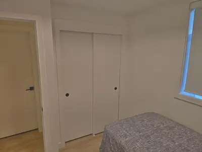 a bedroom with a bed and a white cabinet at A stylish 2 BDR with a blend of cozy and peace! in Calgary
