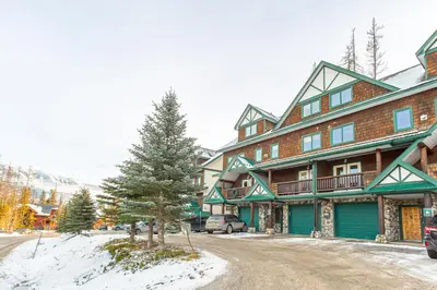 a large building with a tree in front of it at Cedar Ridge Estates by StayIn in Fernie