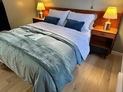 a bed in a bedroom with two lamps on a night stand at Eagle Way in Port Renfrew