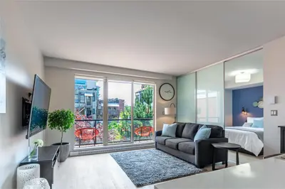 a living room with a couch and a bed and a window at Executive Condo In Old Town Victoria in Victoria