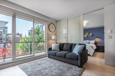 a living room with a couch and a large window at Executive Condo In Old Town Victoria in Victoria