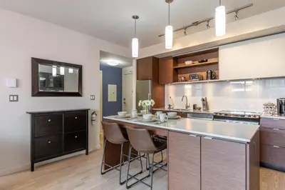 a large kitchen with a counter and stools at Executive Condo In Old Town Victoria in Victoria
