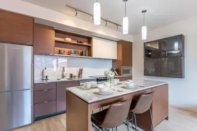 a kitchen with a large island with bar stools at Executive Condo In Old Town Victoria in Victoria