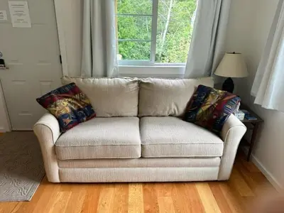 a white couch in a living room with a window at Silva Bay View BnB in Gabriola