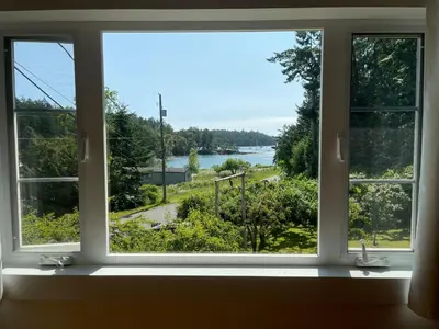a window with a view of a lake seen through it at Silva Bay View BnB in Gabriola