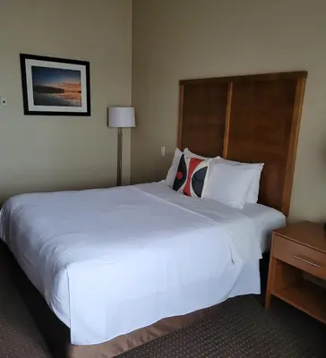a large white bed in a hotel room at The Kanata Bonnyville in Bonnyville