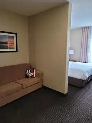 a hotel room with a couch and a bed at The Kanata Bonnyville in Bonnyville